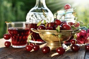 cherry liqueur in crystal carafe and fresh fruits Najlepsze owocowe nalewki. Zobacz, jak prosto zrobić – domowe sposoby.